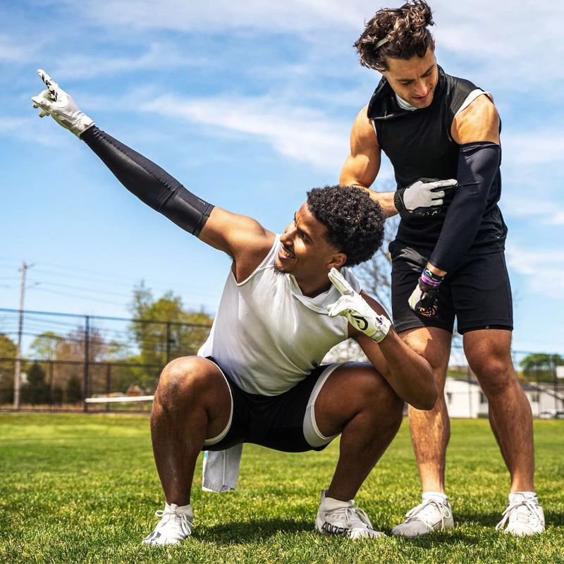Two athletes training on a grass field with Vettex training gear