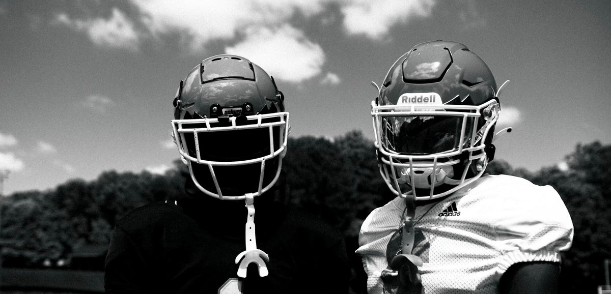 Two football players in helmets wearing Vettex gear